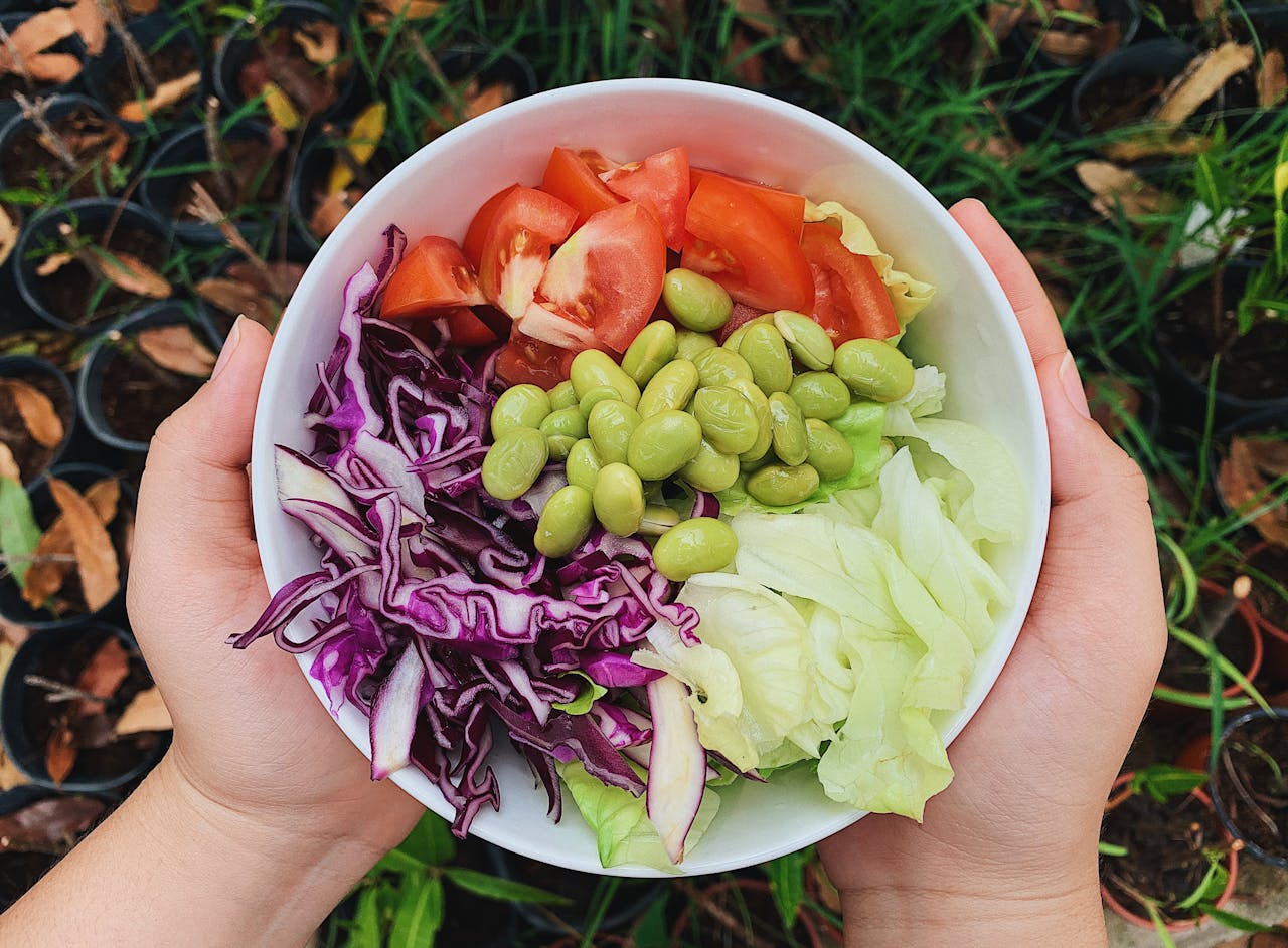 why-choose-us A vibrant bowl of fresh garden salad featuring tomatoes, edamame, and cabbage. Perfect for healthy dining.